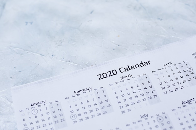 Primo piano di un calendario 2020 su una superficie strutturata bianca