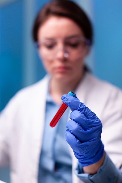 Primo piano di un campione di sangue trattenuto da un medico scienziato in ospedale