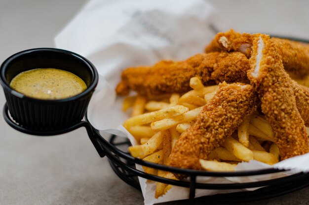 Primo piano di un cesto Cajun con salsa e patatine