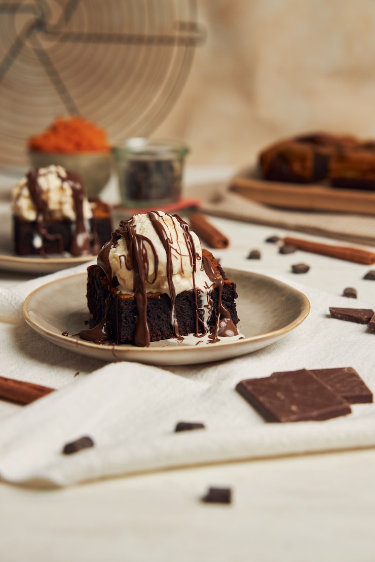 Foto gratuito primo piano di un delizioso brownie al cioccolato di zucca appena sfornato con gelato su un piatto
