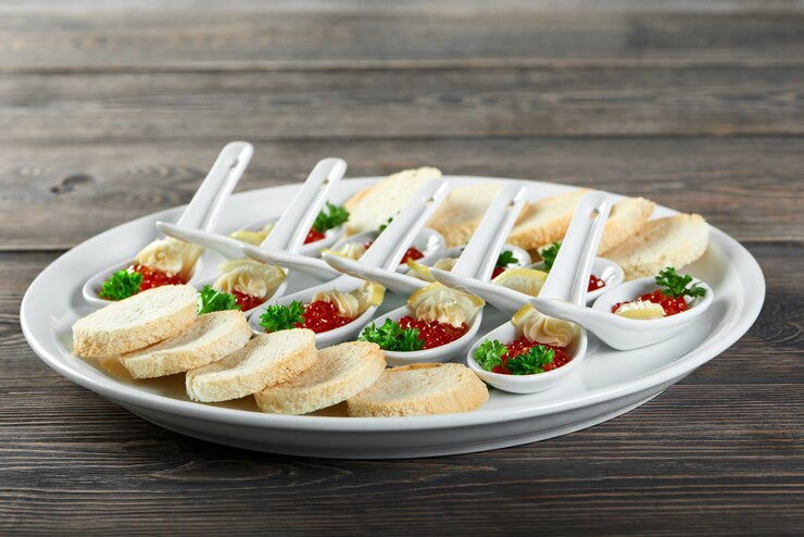 Foto gratuito primo piano di un grande piatto, servito per un ristorante a buffet con gustosi snack a base di caviale rosso, pane bianco, fette di limone e panna. sembra molto delizioso e buono per banchetti e catering.