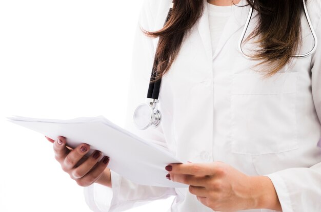 Primo piano di un medico femminile che tiene il rapporto medico a disposizione isolato sul contesto bianco