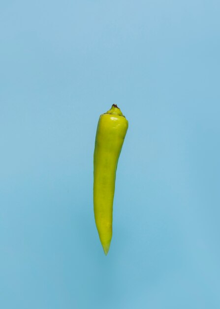 Primo piano di un peperoncino verde sulla superficie blu