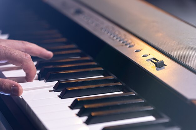 Primo piano di un sintetizzatore o di un tasto di pianoforte in una splendida illuminazione scenica.