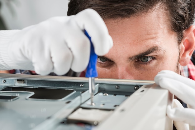 Primo piano di un tecnico maschio che ripara CPU con il cacciavite