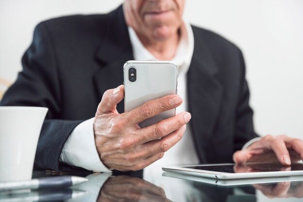 Primo piano di un uomo anziano che tiene in mano smart phone