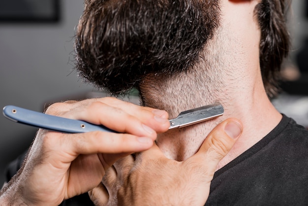 Primo piano di un uomo che si rade la sua barba con il rasoio