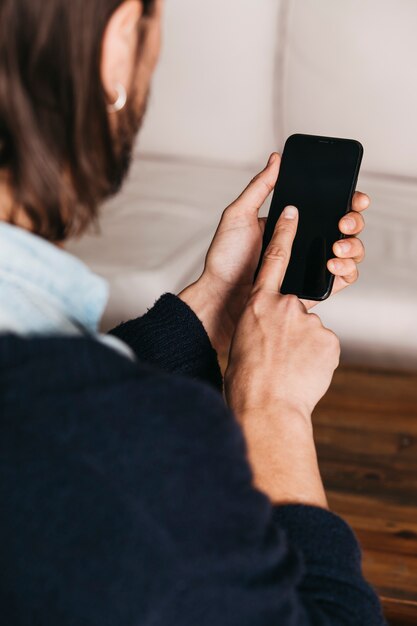 Primo piano di un uomo che tocca il dito sullo schermo mobile del touch screen