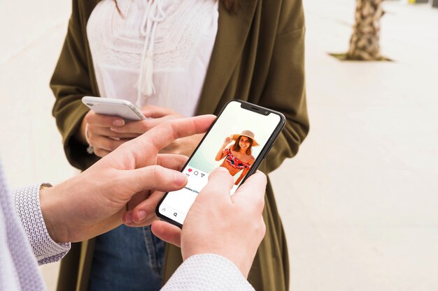 Primo piano di un uomo che usando app social media su smartphone