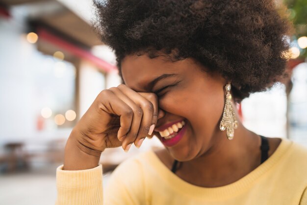 Primo piano di una bella donna latina afroamericana sorridente e trascorrere del bel tempo presso la caffetteria.