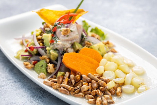 Primo piano di una deliziosa insalata con verdure ed erbe in un piatto sul tavolo