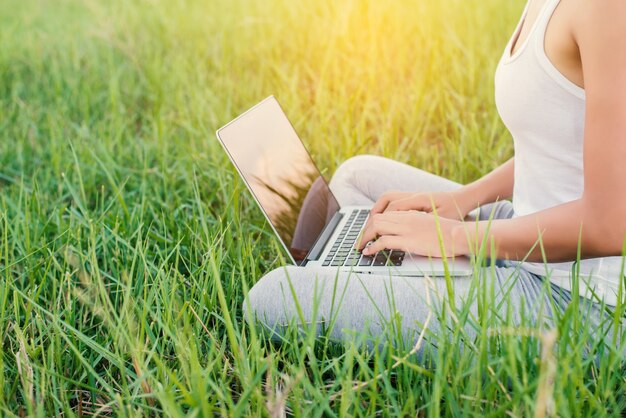 Primo piano di una donna che lavora con il suo computer portatile all&#39;aperto