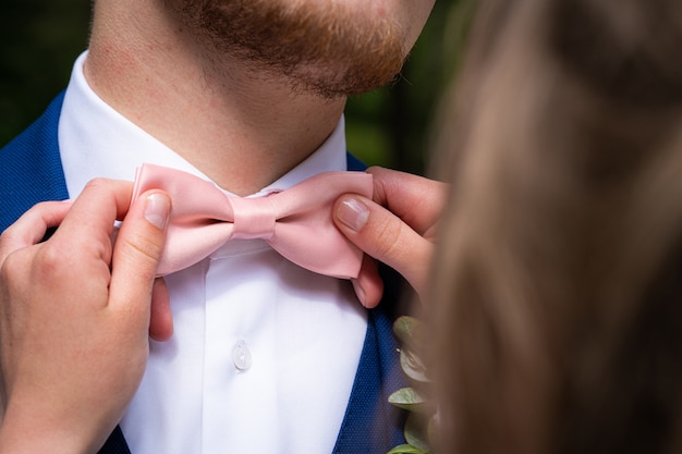 Primo piano di una femmina che tiene il papillon rosa del maschio