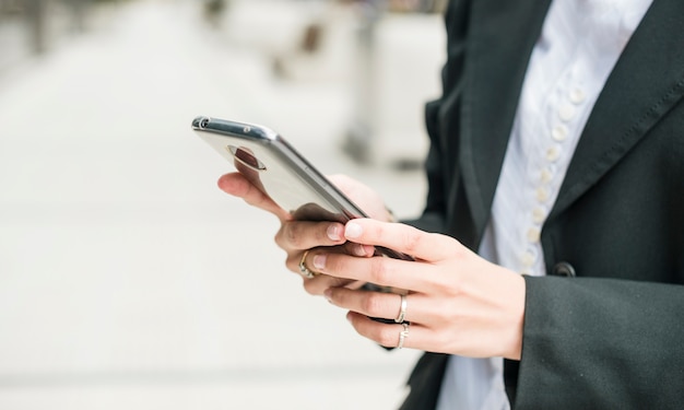 Primo piano di una giovane imprenditrice utilizzando smartphone