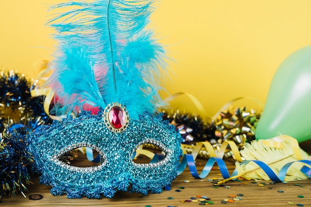 Primo piano di una maschera di carnevale veneziano blu con piuma e materiale di decorazione del partito