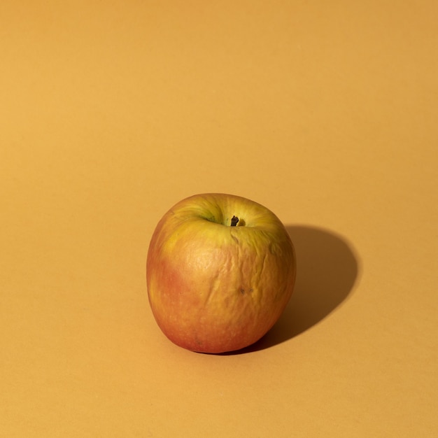 Primo piano di una mela su sfondo giallo
