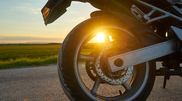 Primo piano di una moto su uno sfondo al tramonto
