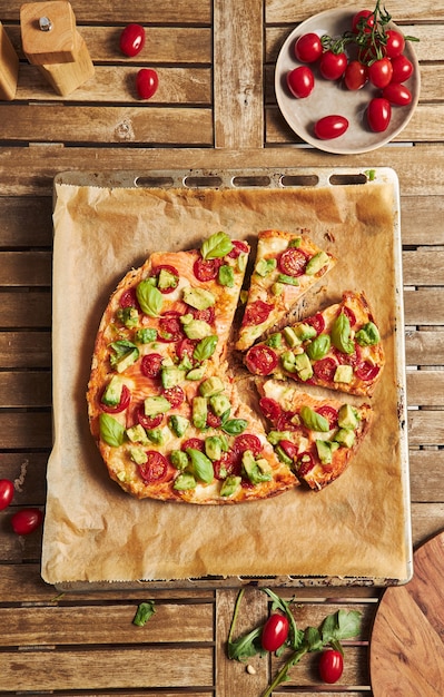 Primo piano di una pizza con verdure su un tavolo di legno