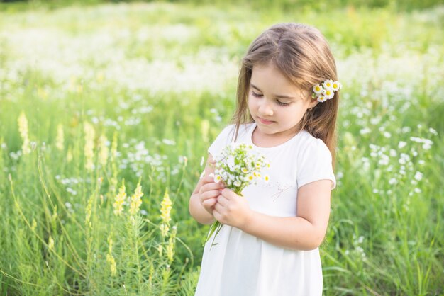 Primo piano di una ragazza che raccoglie fiori bianchi in mano