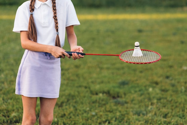 Primo piano di una ragazza che tiene il volano su badminton