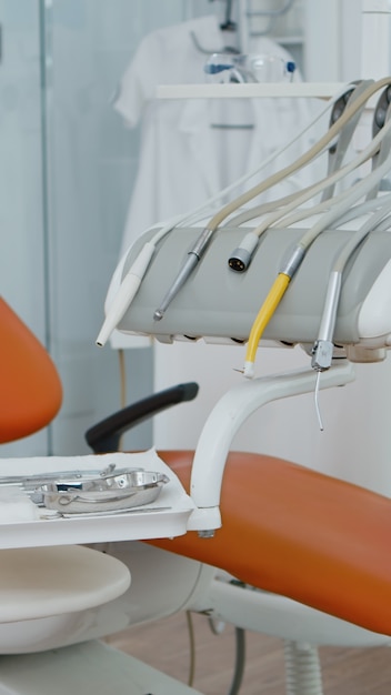 Primo piano di una sedia dentale nell'ufficio vuoto dell'ospedale di stomatologia del dentista con nessuno dentro