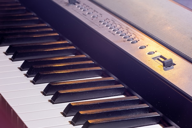 Primo piano di una tastiera di pianoforte elettronica in bella illuminazione.