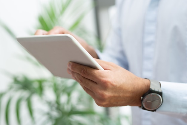 Primo piano di uomo d&#39;affari con orologio da polso con tablet