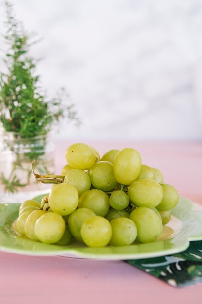 Primo piano di uva verde succosa sul piatto