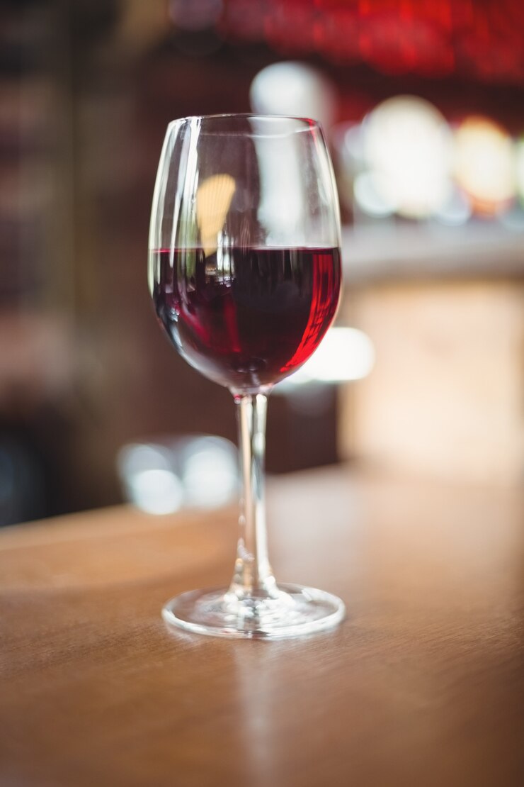 Foto gratuito primo piano di vetro con vino rosso sul tavolo
