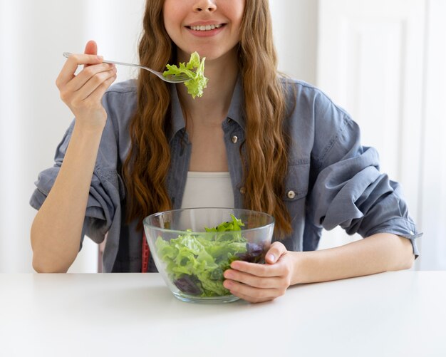 Primo piano donna che mangia insalata