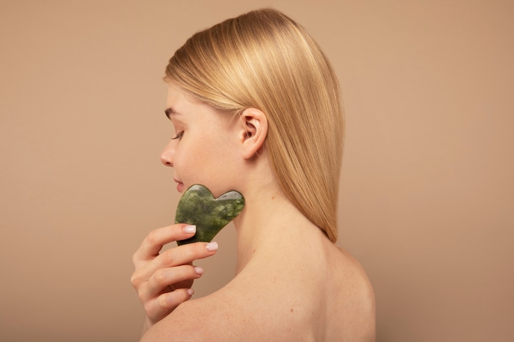 Foto gratuito primo piano donna che massaggia il viso con uno strumento
