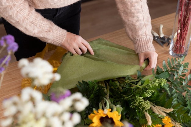 Primo piano fiorista che fa bouquet