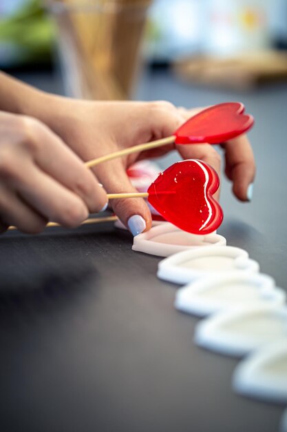 Primo piano il processo di creazione di lecca-lecca a forma di cuore