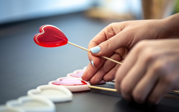 Primo piano il processo di creazione di lecca-lecca a forma di cuore