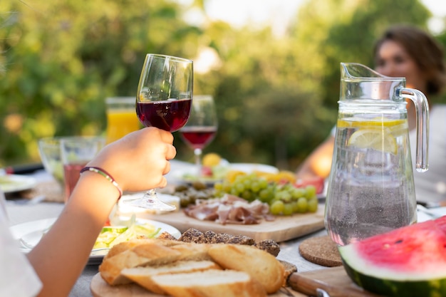 Primo piano mano che tiene il bicchiere di vino