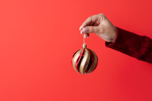 Primo piano mano che tiene l'ornamento di natale