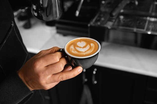 Primo piano mano che tiene tazza di caffè