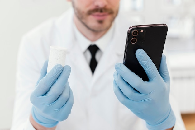 Primo piano medico che tiene smartphone