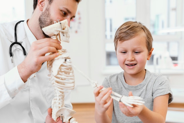 Primo piano medico e bambino con scheletro