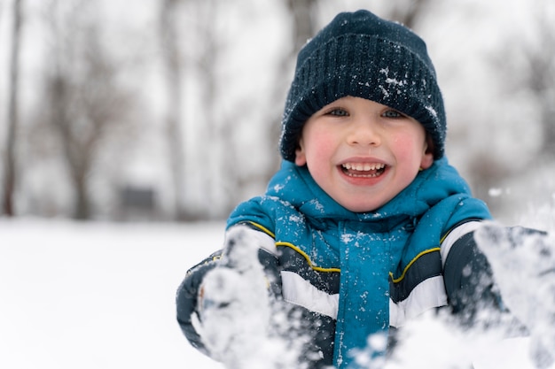 Primo piano n bambino felice che gioca nella neve