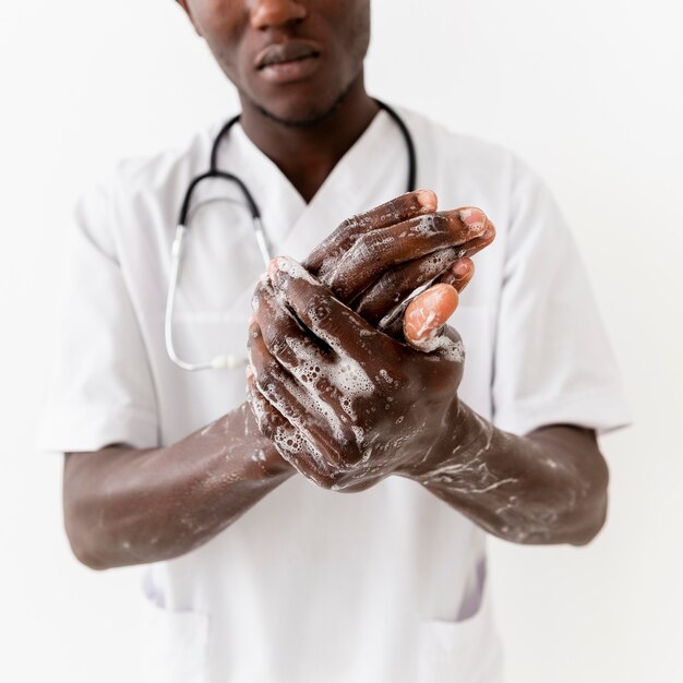 Primo piano professionale delle mani di lavaggio di giovane medico