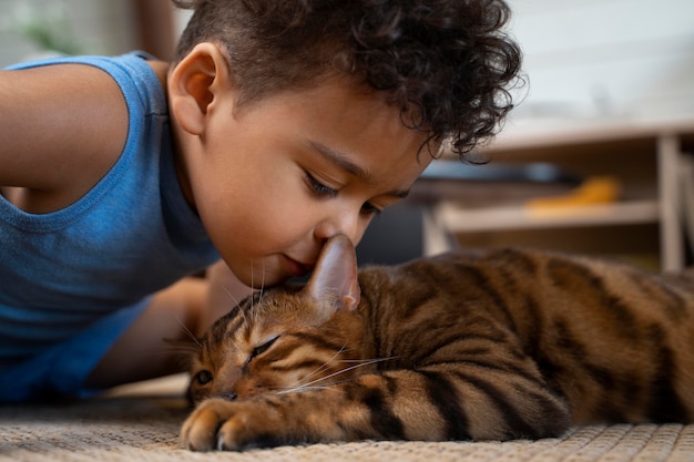 Primo piano ragazzo che bacia un simpatico gatto