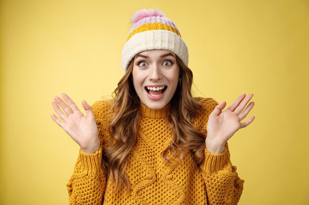 Primo piano sorpreso eccitato stupito donna attraente che urla felicemente alzando le mani si chiedeva stupito vincendo lotteria sentire fantastiche notizie perfette, festeggiando sorridendo ampiamente, sfondo giallo