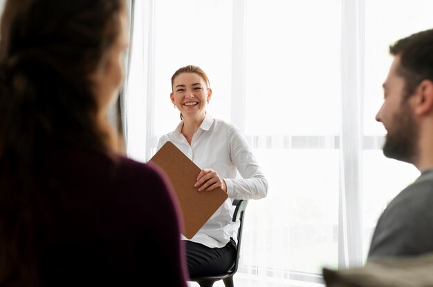 Primo piano sorridente terapista con i pazienti