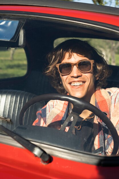 Primo piano sorridente uomo alla guida di un'auto