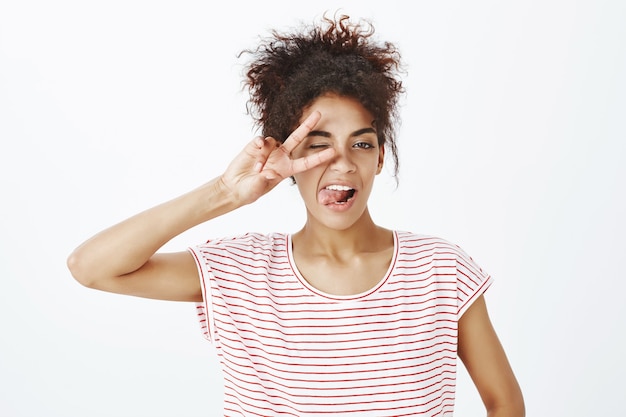 Primo piano sparato di ougoing donna sicura di sé con acconciatura afro in posa in studio