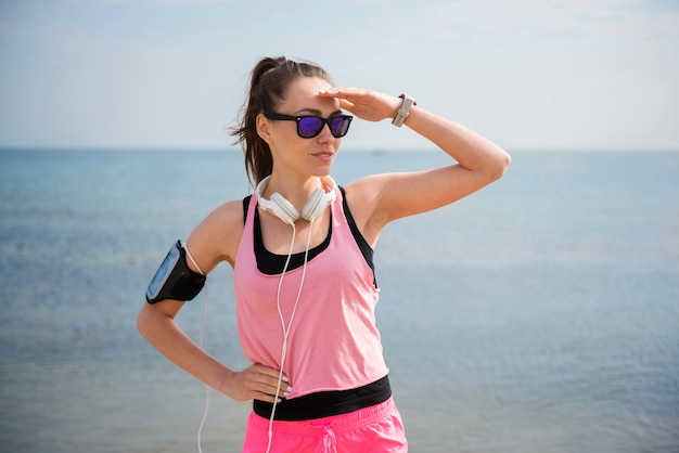 Primo piano su giovane persona in forma fare jogging in riva al mare