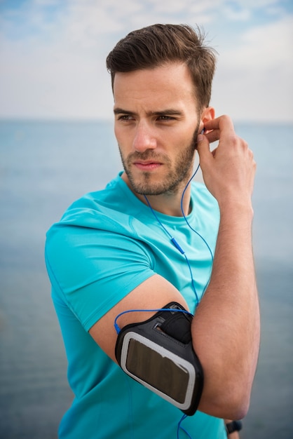 Primo piano su giovane persona in forma fare jogging in riva al mare