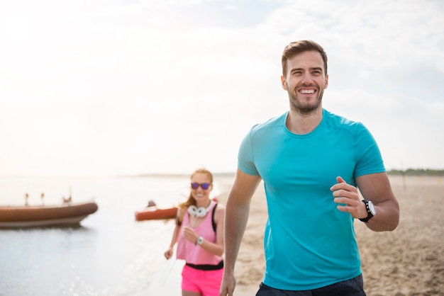 Primo piano su giovani in forma fare jogging in riva al mare