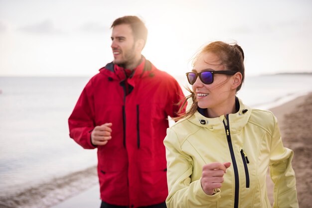 Primo piano su giovani in forma fare jogging in riva al mare